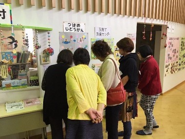 女性5名が壁に貼られた作品などを眺めている写真