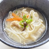 餃子と人参やもやし、しめじ等のカット野菜が入ったスープの写真
