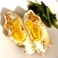 油揚げげの袋状の中に割り入れた卵を煮た写真